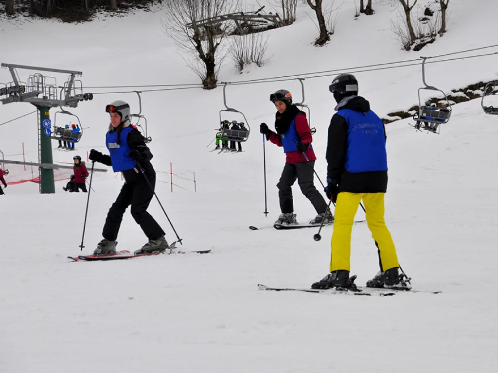 Skifahrende unterhalb des Sessellifts auf der Piste.